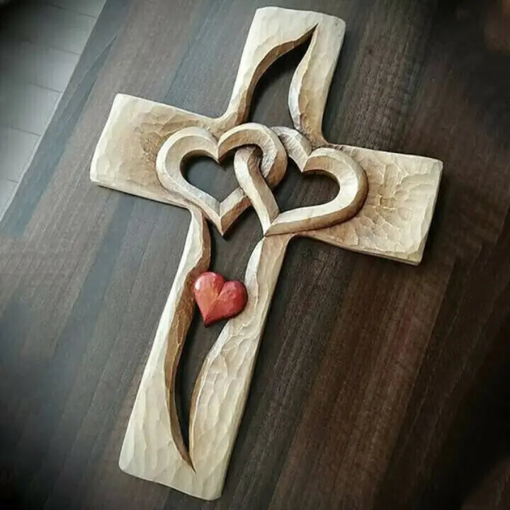 Handgeschnitztes Holzkreuz mit ineinander verschlungenen Herzen