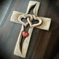 Handgeschnitztes Holzkreuz mit ineinander verschlungenen Herzen